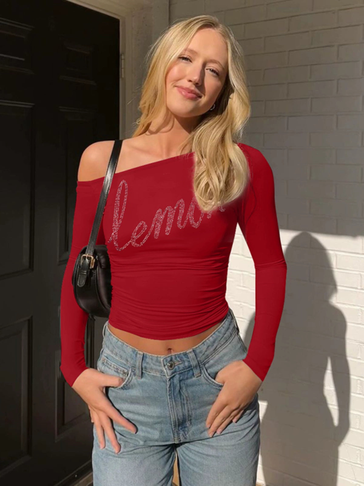 Shemoda: Zane Sparkle Top | Nüra - Shop Shemoda's Zane Sparkle Top: a vibrant, asymmetric crop with rhinestone "lemon" script. Stand out in style with this bold, one-shoulder design. - $19.00