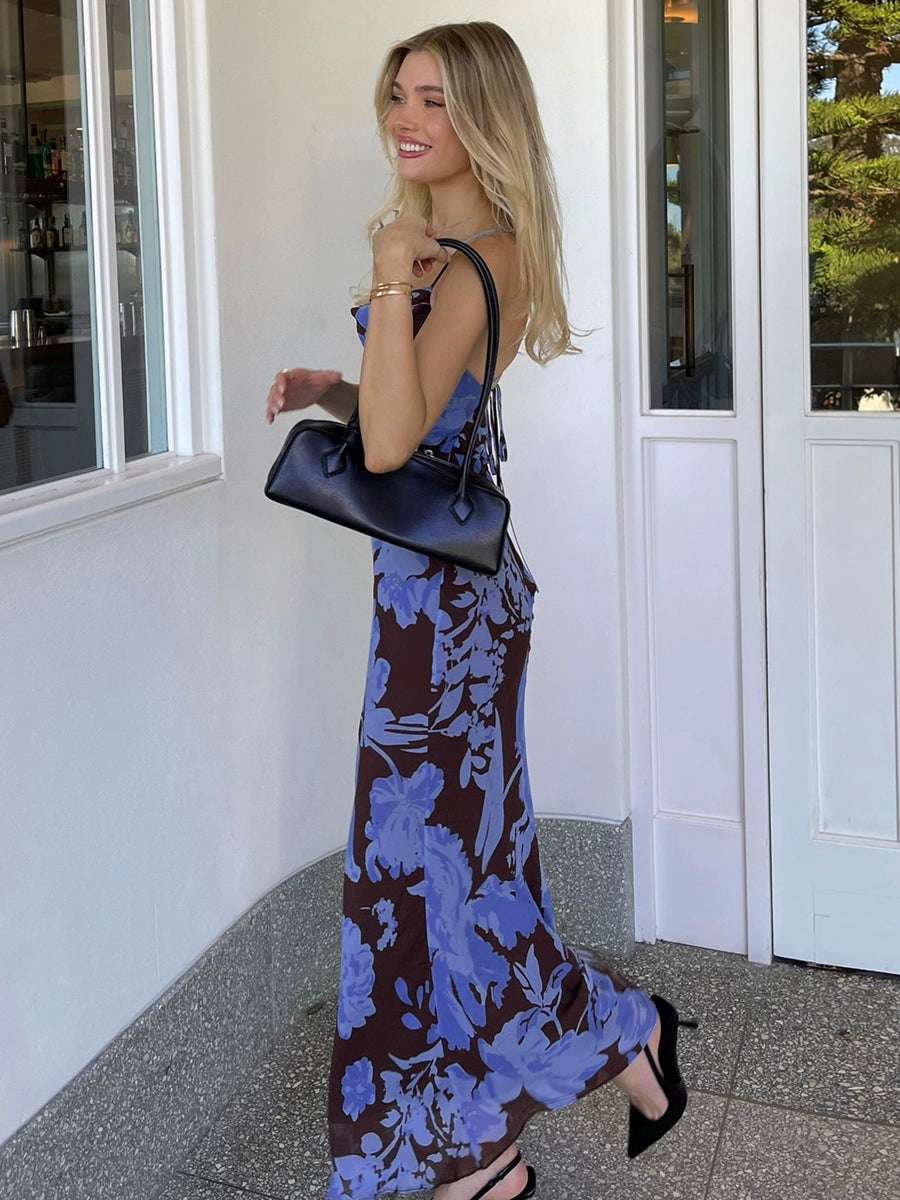 Shemoda: Ocean Bloom Dress | Nüra - Discover Shemoda's Ocean Bloom Dress: a bold blue floral maxi with crisscross straps and backless design. Perfect for vacations and warm events. - $24.00
