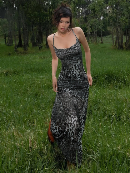 Shemoda: Willow Wildprint Dress | Nüra - Discover Shemoda's Willow Wildprint Dress: a bold leopard print with a backless cut, draped neckline, and flowing mesh skirt for effortless elegance. - $21.00