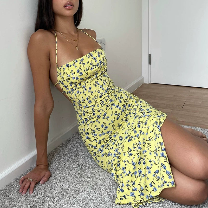 Shemoda: Flora Blossom Dress | Nüra - Discover Shemoda's Flora Blossom Dress: an elegant, sleeveless maxi with a tie-back neckline. Yellow with blue florals for a fresh, confident style. - $19.00