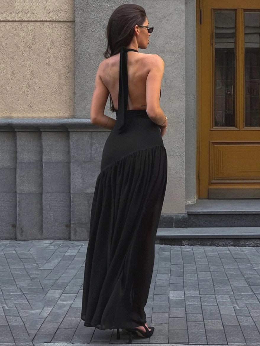 Shemoda: Delia Evening Maxi Dress | Nüra - Elevate your style with Shemoda's Delia Evening Maxi Dress. A black, backless halter dress with a ruffled neckline and elegant mesh skirt. - $27.00