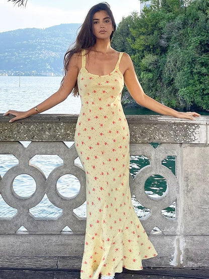 Shemoda: Raya Sundress | Nüra - Discover Shemoda's Raya Sundress: a sleeveless yellow floral dress with a scoop neck and fishtail hem, perfect for elegant warm-weather events. - $20.00